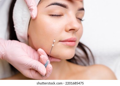 Operación de sutura de DOP de elevación de cara. técnica innovadora de elevación de hilo nuevo, cosmetólogo preparándose para hacer el procedimiento a la cliente femenina, seleccione la opción de hilo apropiada