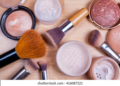 Face makeup cosmetics on a light wooden floor - brush, powder, blush, foundation. - Shutterstock ID 416087221