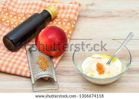 Face mask from apple,  fat cream and olive oil.  Ingredients for easy homemade facial mask on wooden background
