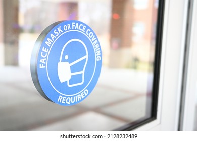 Face Mask Or Face Covering Required Sign On A Store Front Door. Mask Mandate Policy In Public Places