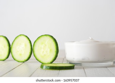 face mask with cucumber slices, white wood background - Shutterstock ID 163957037