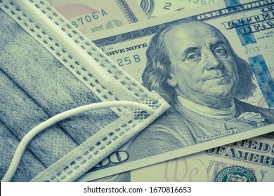 Face Mask On US Dollar Bill Banknote Background. Global Novel Coronavirus (Covid-19) Outbreak Effect To World Economy And Financial Crisis, Travel Hotel Business. Coronavirus Detected In Wuhan, China.