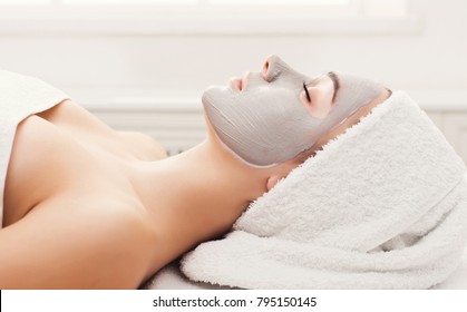 Face Mask, Spa Beauty Treatment. Woman Applying Facial Clay Mask At Spa Salon, Skincare, Side Vies