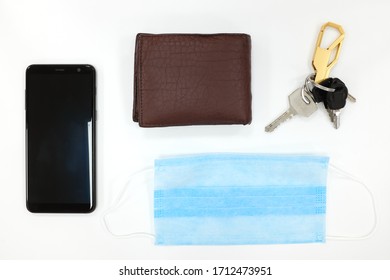 Face Mask, Wallet, Mobile Phone And Keys Flat Lay. New Normal Concept During Covid-19 Coronavirus Pandemic Crisis.