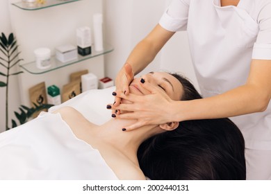 Face Massage in beauty spa salon. Caucasian woman receiving a facial massage at an aesthetic salon. Spa facial Massage. Body care, skin care, wellness, wellbeing, beauty treatment concept