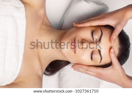 Face massage.  Close-up of young woman getting spa massage treatment at beauty spa salon.Spa skin and body care. Facial beauty treatment.Cosmetology.