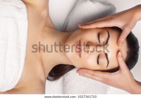 Face massage.  Close-up of young\
woman getting spa massage treatment at beauty spa salon.Spa skin\
and body care. Facial beauty\
treatment.Cosmetology.