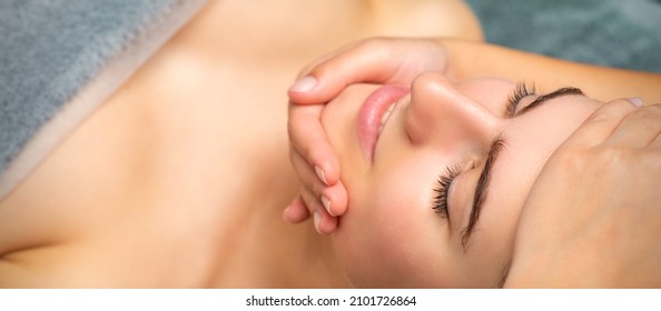 Face massage of detox therapy for the pretty female patient at spa salon. - Shutterstock ID 2101726864