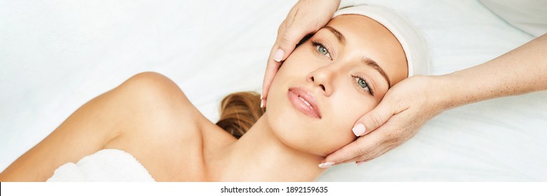 Face massage at spa salon. Doctor hands. Pretty female patient. Beauty treatment. Healthy skin procedure. Young woman head. Light background. Scrub rejuvenation. Facial dermatology mask. Detox therapy - Shutterstock ID 1892159635
