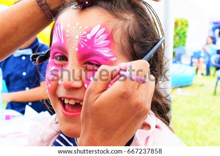 Face painting, artist painting a child as Butterfly.
