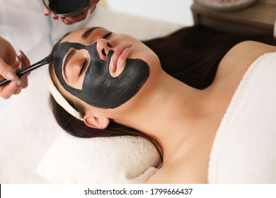 Face peeling mask, spa beauty treatment, skincare. Woman getting facial care by beautician at spa salon, side view, close-up - Powered by Shutterstock