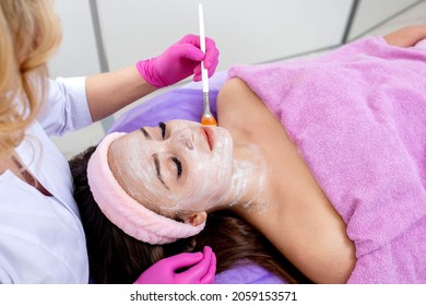 Face Peeling Mask, Spa Beauty Treatment, Skincare. Woman Getting Facial Care By Beautician At Spa Salon, Side View, Close-up. Anti-aging Treatment. Cosmetology And Professional Facial Skin Care