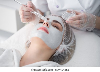 Face Peeling Mask, Spa Beauty Treatment, Skincare. Woman Getting Facial Care By Beautician At Spa Salon