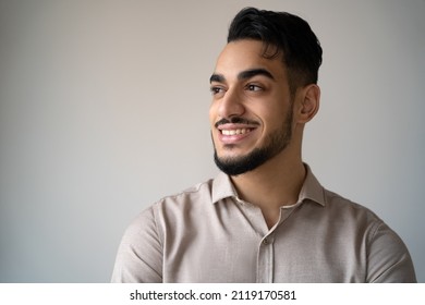 Face Portrait Of Happy Indian Man Looking Aside With Toothy Smile Isolated Over Blank Grey Copy Space. Studio Headshot Of Young Hindu Male Entrepreneur, Leader Or Successful Freelance Worker