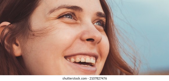 face portrait of a happy red-haired young mother walking in nature on the lawn, close up woman's emotions life concept - Shutterstock ID 2107827476