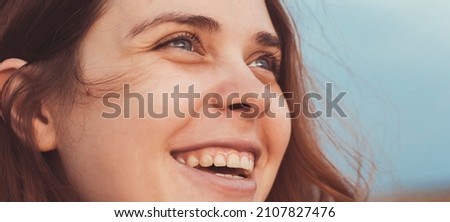face portrait of a happy red-haired young mother walking in nature on the lawn, close up woman's emotions life concept