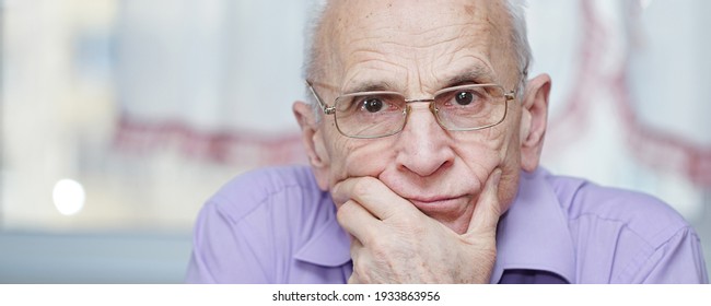Face portrait of older sad man with pensive look in glasses. Concept wisdom and oldness.