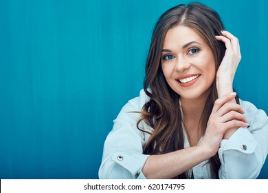 Face Portrait Of Young Woman Smiling With Teeth. Girl With Long Hair On Blue Wall Background.