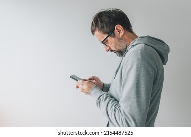 Face Profile Portrait Of Casual Mid-adult Male Person Using Mobile Smart Phone Indoors, Selective Focus