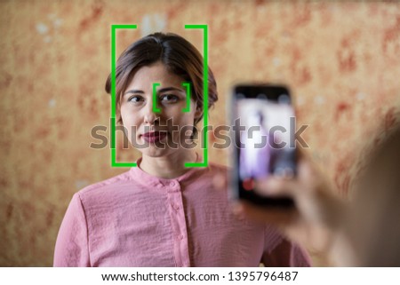 face recognition technology activated while taking a photo of a young woman with mobile phone