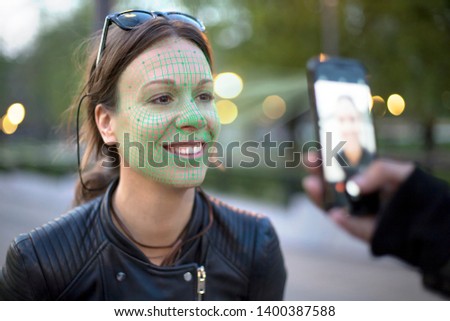 face recognition technology activated while taking a photo of a young woman with mobile phone