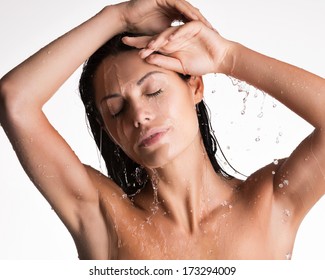 Face of a  relaxing wet woman in shower under the water