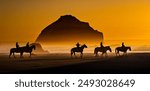 Face Rock, with silhouettes of horses and riders, and other sea stacks at sunset on the southern Oregon coast at Bandon