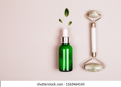 Face Roller And Serum On Grey Background. Flat Lay Style. Modern Selfcare Concept.