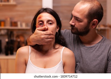 Face Of Scared Woman Victim While Man Covers Her Mouth. Violent Aggressive Husband Abusing Injuring Terrified Helpless, Vulnerable, Afraid, Beaten And Panicked Wife.