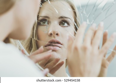 Face Of Schizophrenic Woman Reflected In Broken Mirror
