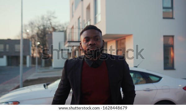 Face
serious african american man stand near white car look at camera
sunset young vehicle open passenger arm auto street automobile
businessman buy jacket portrait close up slow
motion