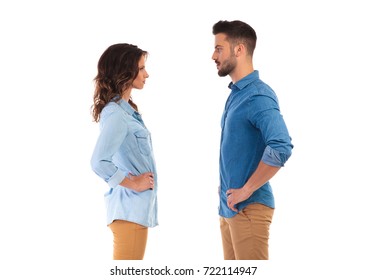 face to face serious casual couple with hands on waist, on white background