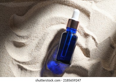 Face Serum Of Glass Bottle With A Pipette On A Natural Background With Sand. Essential Oil For Moisturizing Body Skin. Mockup Of Beauty Fashion Cosmetic Bottle Dropper Product With Skincare Concept.