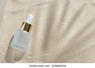 Face Serum Of Glass Bottle With A Pipette On A Natural Background With Sand. Essential Oil For Moisturizing Body Skin. Mockup Of Beauty Fashion Cosmetic Bottle Dropper Product With Skincare Concept.