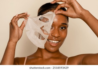 Face sheet mask, moisturizing beauty product. Skincare and beauty concept with woman wearing a beauty face mask. Sheet mask. African American beautiful woman. - Powered by Shutterstock