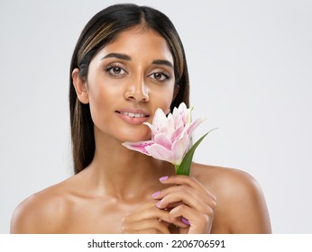 Face Skin Care. Beauty Indian Model Smelling Lotus Flower. Beautiful Woman Portrait With Natural Make Up And Smooth Skin. Women Facial Spa Massage Cosmetology Over White