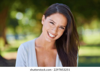 Face, smile and portrait of a woman happy in a park in summer for beauty, excited and confident in nature. Head, garden and female person or model outdoor with freedom, happiness and style