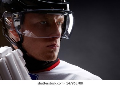 Face of sportsman in protective helmet over black background