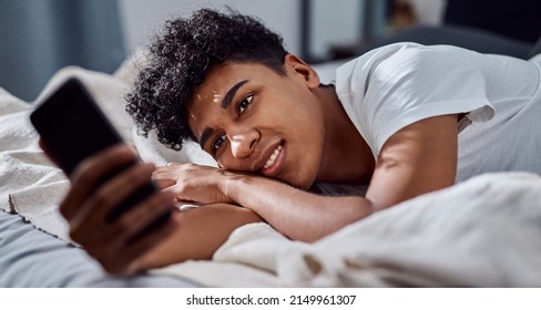 Face Time With Me. Shot Of A Young Man Relaxing On His Bed And Taking Selfies With A Smartphone.