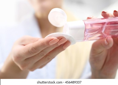 Face Tonic. The Woman Pours A Cosmetic Tonic On A Cotton Pad.