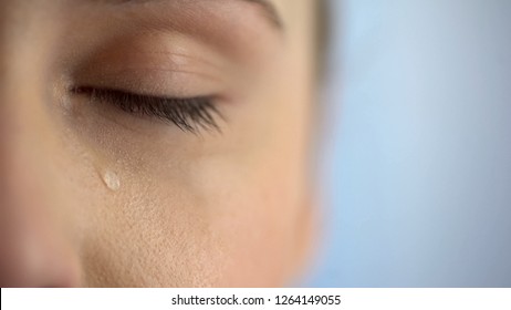 Face of unhappy woman crying, closeup eye with teardrops, life problems anguish