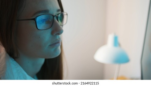 Face Of Woman With Glasses Looking At The Monitor. Reflection Of The Screen In Glasses, Tired Eyes, Work At The Computer, Protective Glasses From The Monitor. Focused Looking.