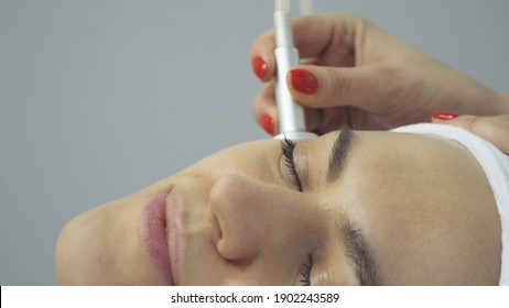 Face of woman having oxygen facial treatment in beauty salon, close up