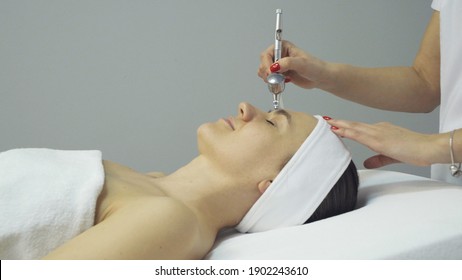 Face of woman having oxygen facial treatment in beauty salon, close up