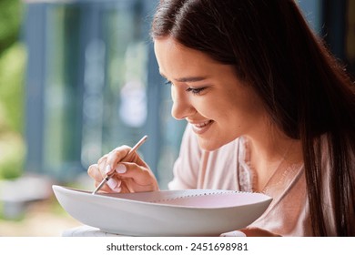 Face, woman and painting ceramics for creativity, art workshop or class with hobby, paintbrush and material. Closeup, craft and pottery lesson with watercolor for clay bowl, design and recreation - Powered by Shutterstock