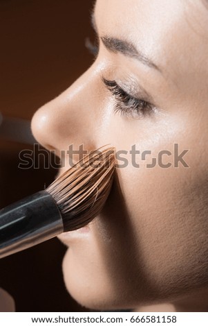 Face of a woman with powder on the skin of cheek