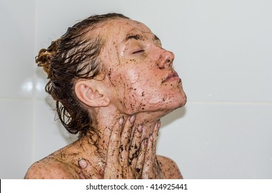 Face of young beautiful sexy girl with long hair girl who takes a bath naked in the spa procedures, wellness dealt a protective mask of coffee for skin health