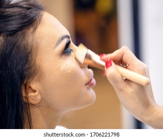 The face of a young girl whose makeup artist applies makeup with a cosmetic brush - Shutterstock ID 1706221798