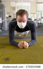 Face Of Young Man With Mask Doing Plank Position On The Floor At Gym During Corona Virus Covid-19