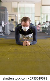 Face Of Young Man With Mask Doing Plank Position On The Floor At Gym During Corona Virus Covid-19